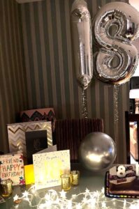 A picture with an 18 birthday balloon and cards