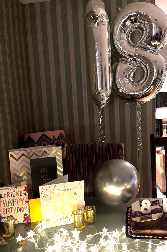 A picture with an 18 birthday balloon and cards